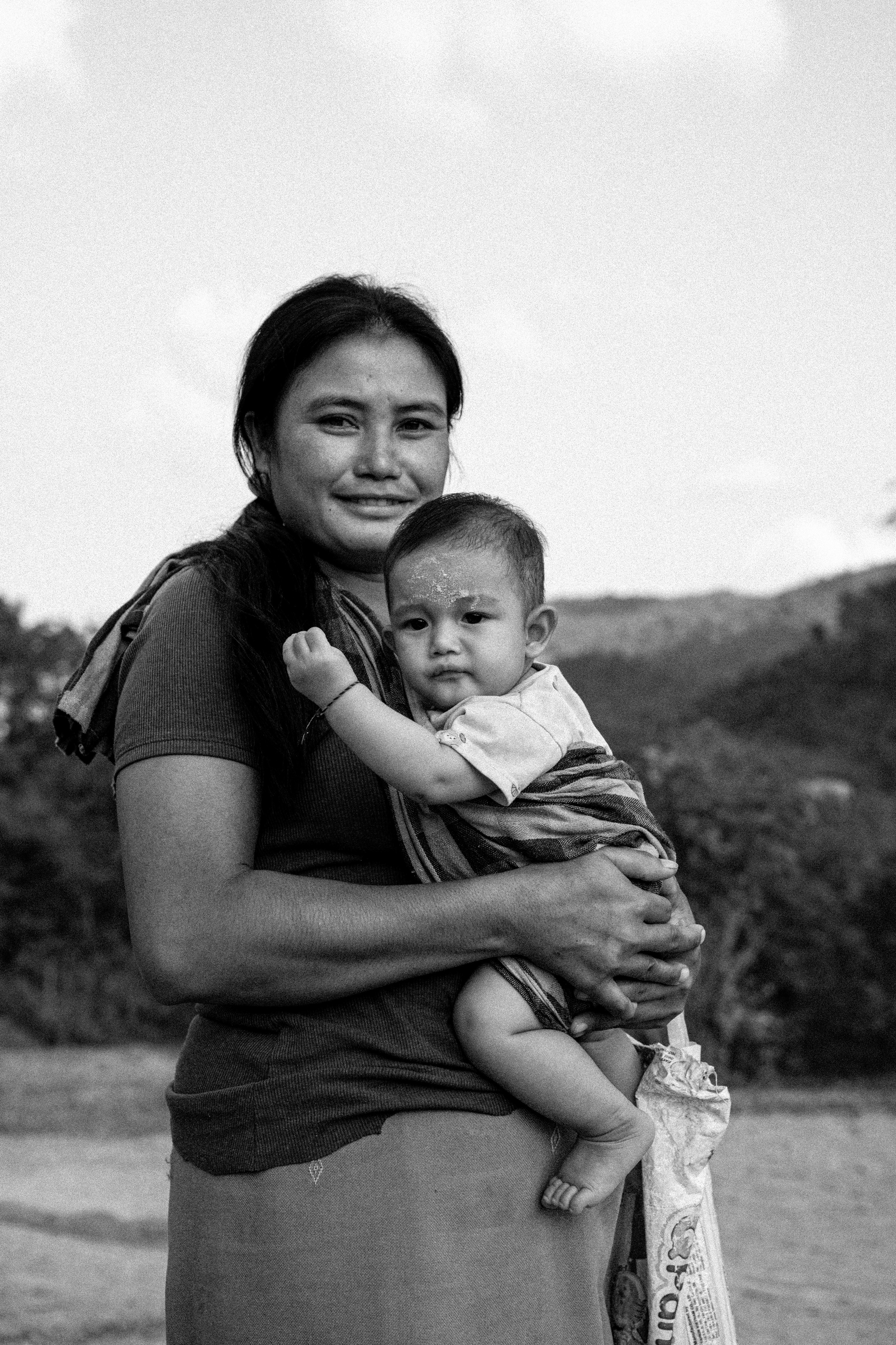 A black-and-white photo of a woman holding her baby.