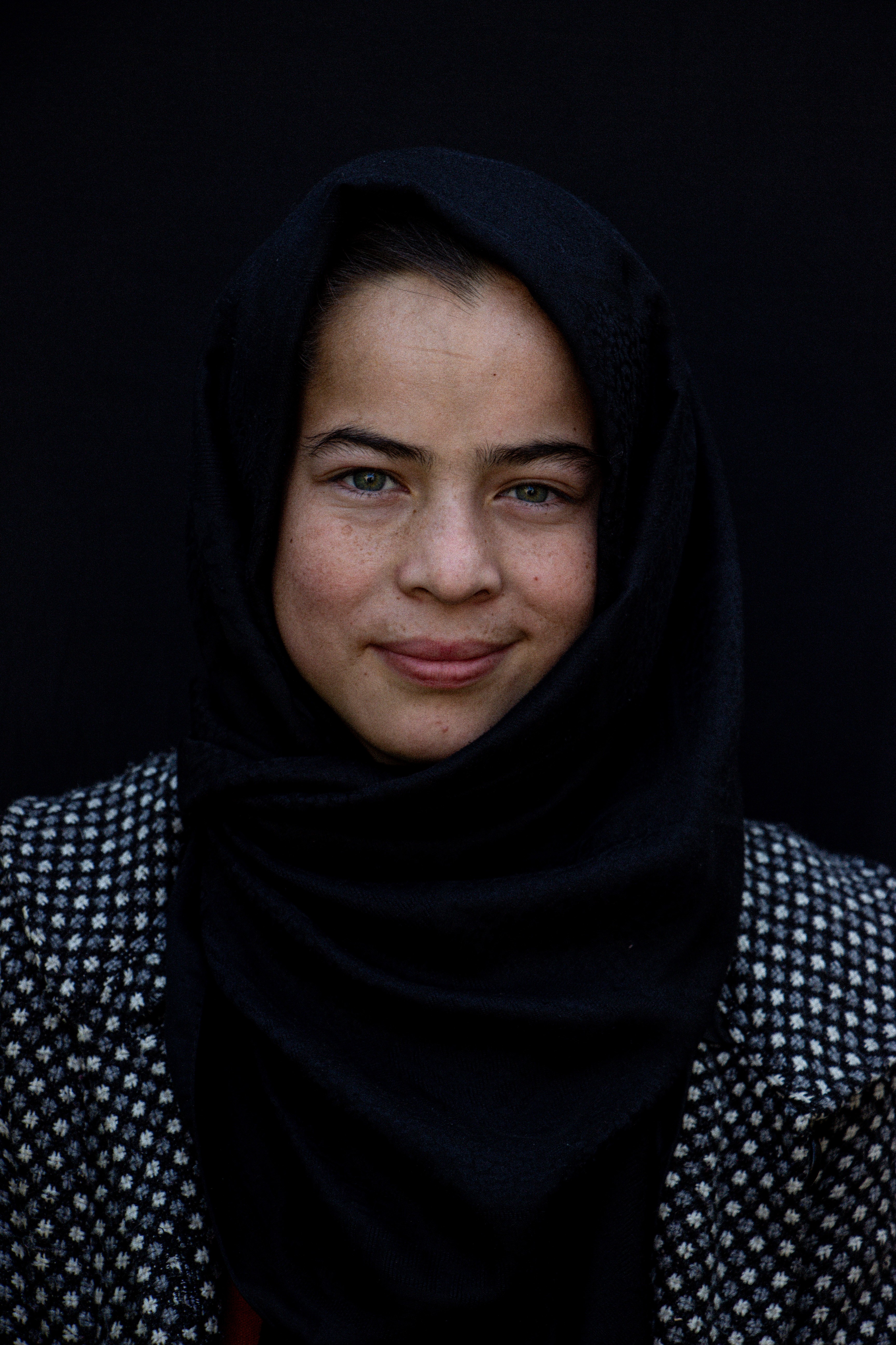 A girl in a headscarf, looking directly into the camera.